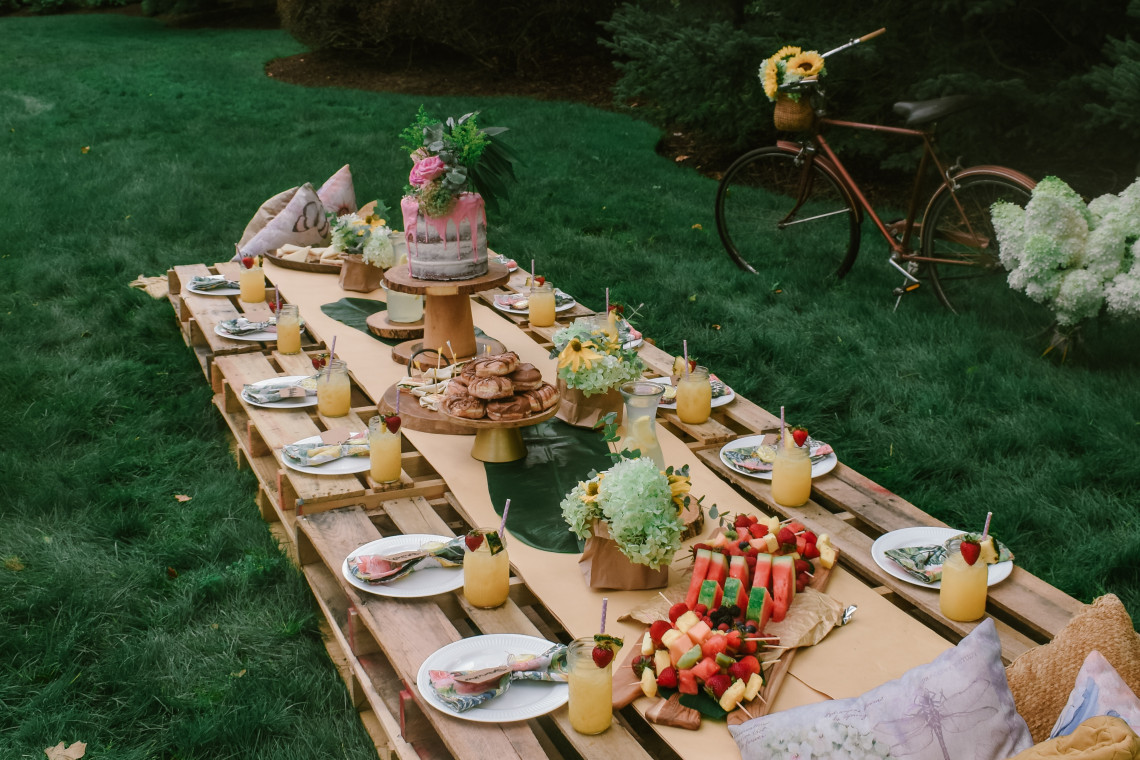 Summer vibes luxury picnics featuring Pina coladas and sunflowers.