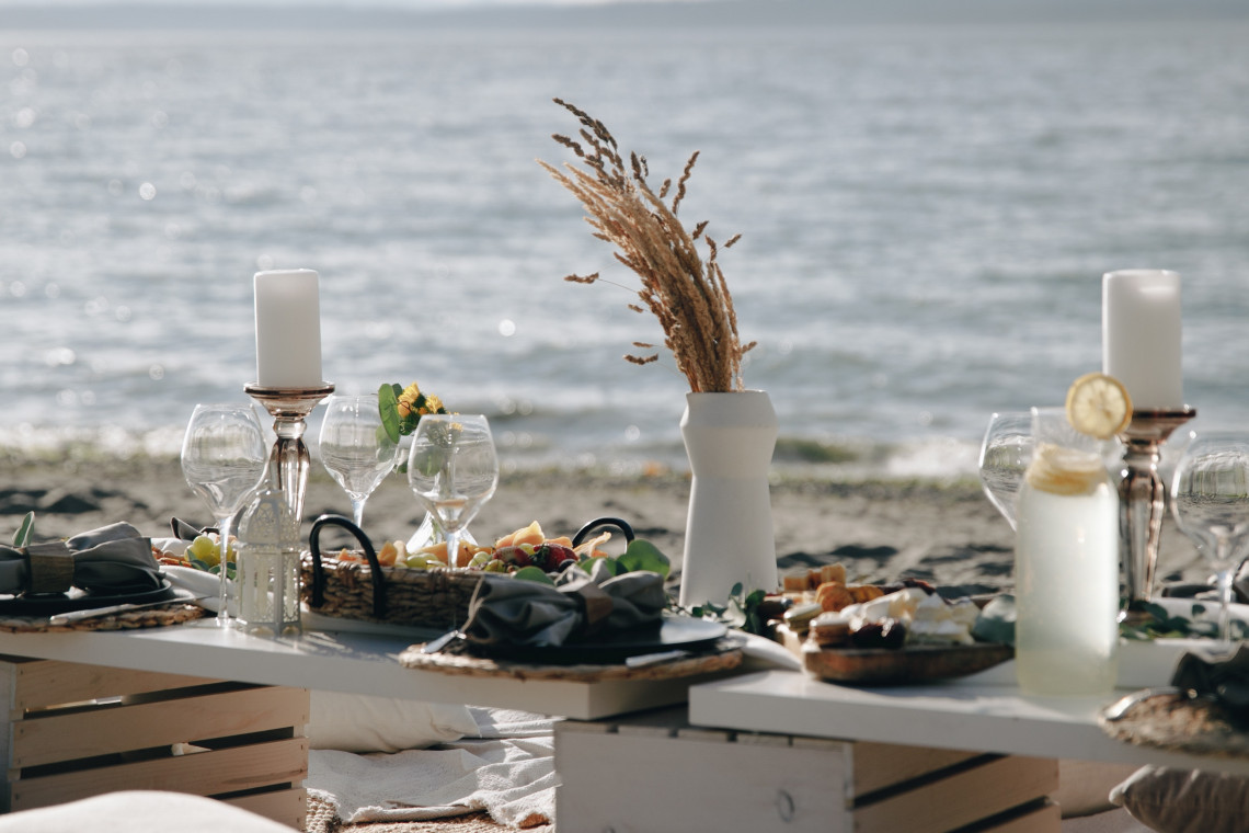 Close up of beach picnic set up featuring fresh lemonade and charcuterie boards.