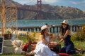 Two friends enjoying a luxury picnic San Francisco set up at Crissy Fields.