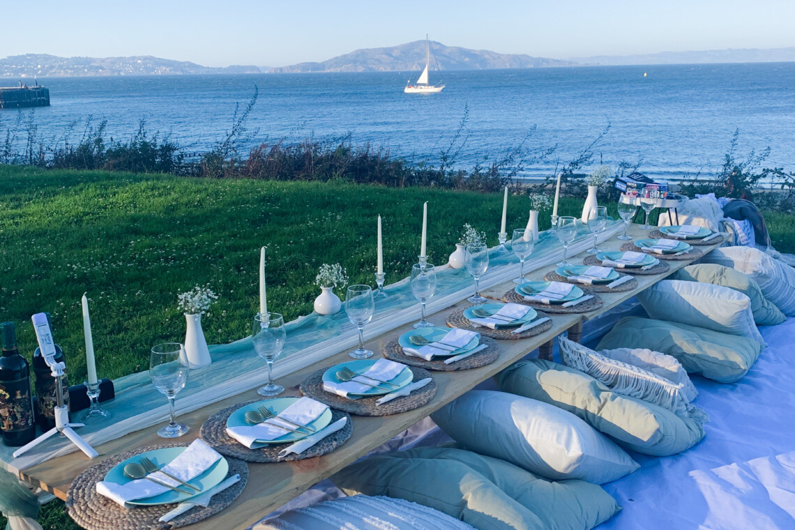 Large 10 person luxury picnic set up featuring the Golden Gate Bridge in San Francisco.