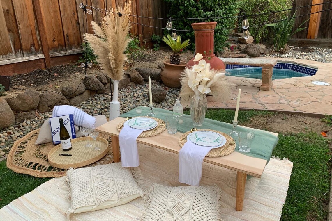 Luxury Picnic at private Bar Area residence with turquoise table runner, hanging lights, and a bottle of wine