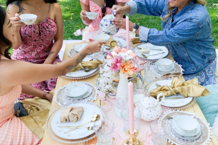 Four ladies enjoying a pink themed luxury picnic with macaron platter at the Golden Gate Park in San Francisco