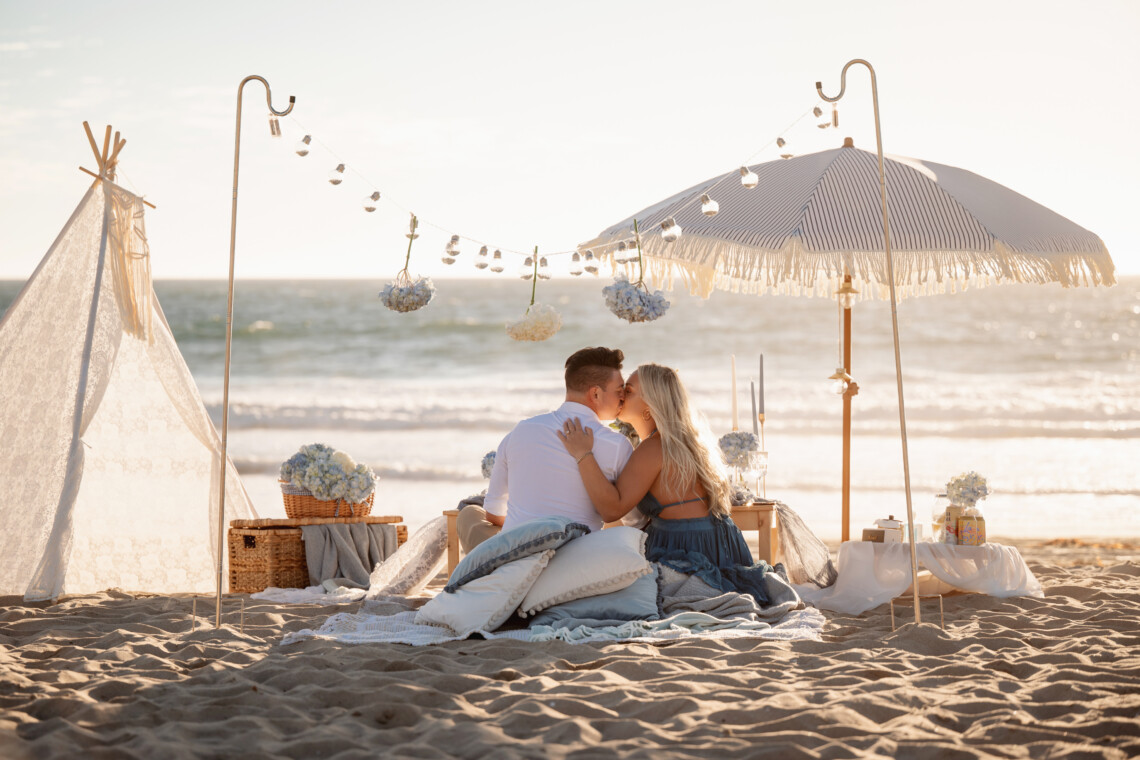 Boho blue luxury picnic with the sunset at the beach